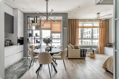 На фото: кухня-столовая среднего размера в современном стиле с серыми стенами, деревянным полом и коричневым полом