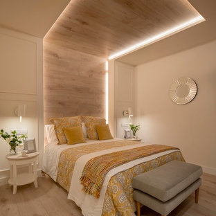 Photo of a large contemporary master bedroom in Bilbao with beige walls, laminate floors, no fireplace and beige floor.