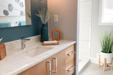 Example of a mid-sized minimalist 3/4 gray tile and porcelain tile porcelain tile, gray floor and single-sink bathroom design in Boston with flat-panel cabinets, medium tone wood cabinets, a one-piece toilet, green walls, an undermount sink, quartz countertops, a hinged shower door, gray countertops and a floating vanity