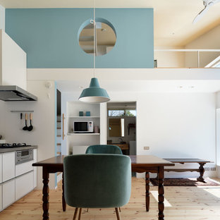 Inspiration for a small scandinavian open plan dining in Other with white walls, light hardwood floors, no fireplace and beige floor.