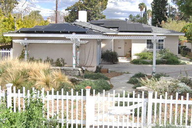 This is an example of a small bungalow detached house in Los Angeles with a pink house and a shingle roof.
