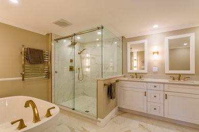 Inspiration for a mid-sized transitional master bathroom in Ottawa with recessed-panel cabinets, white cabinets, a freestanding tub, a corner shower, a bidet, white tile, porcelain tile, beige walls, porcelain floors, an undermount sink, engineered quartz benchtops, white floor, a sliding shower screen and white benchtops.