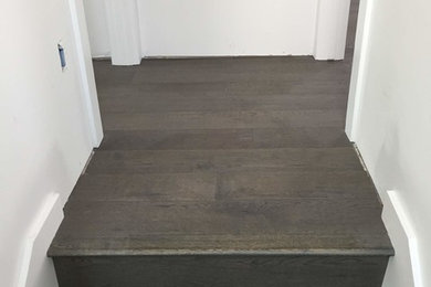 Example of a large minimalist wooden u-shaped staircase design in Austin with wooden risers