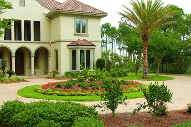 Inspiration for a large mediterranean front yard full sun driveway for summer in Jacksonville with brick pavers.