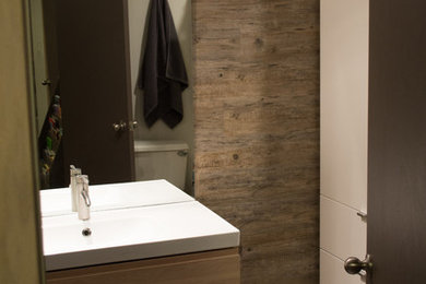 Bathroom - porcelain tile and gray floor bathroom idea in Wichita with flat-panel cabinets, light wood cabinets and solid surface countertops