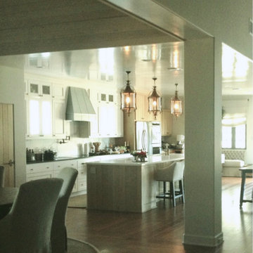 Open dining, kitchen and living room with varying ceiling heights and treatments