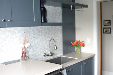 Transitional galley dedicated laundry room photo with an undermount sink, shaker cabinets, blue cabinets and a side-by-side washer/dryer