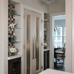 Mittelgroße Moderne Küche in L-Form mit Vorratsschrank, Schrankfronten mit vertiefter Füllung, Quarzwerkstein-Arbeitsplatte, Rückwand aus Glasfliesen, Küchengeräten aus Edelstahl, dunklem Holzboden, Kücheninsel, dunklen Holzschränken, weißer Arbeitsplatte, bunter Rückwand, braunem Boden und Landhausspüle in Birmingham