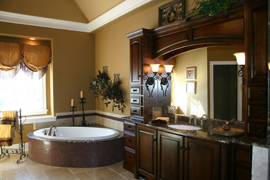 Inspiration for a traditional bathroom in Chicago with an undermount sink, raised-panel cabinets, dark wood cabinets, granite benchtops, a corner tub, an alcove shower, brown tile and ceramic tile.