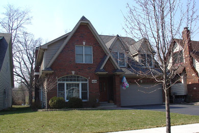 Example of a huge trendy gray two-story brick exterior home design in Chicago