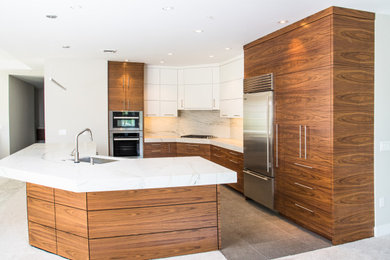 Inspiration for a large contemporary l-shaped porcelain tile and brown floor eat-in kitchen remodel in Portland with an undermount sink, flat-panel cabinets, dark wood cabinets, marble countertops, white backsplash, marble backsplash, stainless steel appliances, an island and white countertops