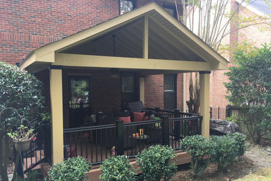 This is an example of a mid-sized eclectic backyard deck in Other with a roof extension.