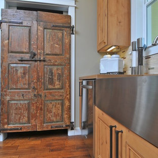 Réalisation d'une arrière-cuisine craftsman en L de taille moyenne avec un évier de ferme, un placard avec porte à panneau surélevé, des portes de placard en bois brun, un plan de travail en béton, une crédence multicolore, une crédence en carreau briquette, un électroménager en acier inoxydable, un sol en bois brun et un îlot central.