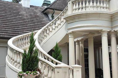 Large tuscan limestone curved mixed material railing staircase photo in Houston with limestone risers