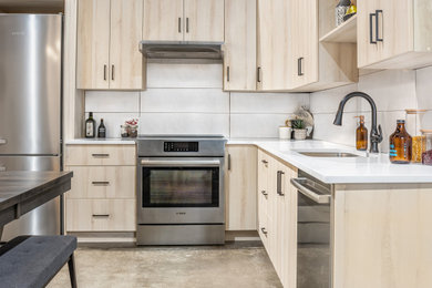 Inspiration for a small transitional l-shaped gray floor and porcelain tile eat-in kitchen remodel in Calgary with an undermount sink, flat-panel cabinets, light wood cabinets, quartz countertops, porcelain backsplash, stainless steel appliances, no island, beige backsplash and white countertops
