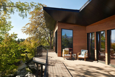 Example of a minimalist backyard second story metal railing deck design in Salt Lake City with a roof extension