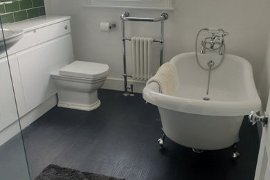 Design ideas for a medium sized family bathroom in West Midlands with a freestanding bath, a one-piece toilet, laminate floors, an integrated sink, grey floors, white worktops, a single sink and a built in vanity unit.