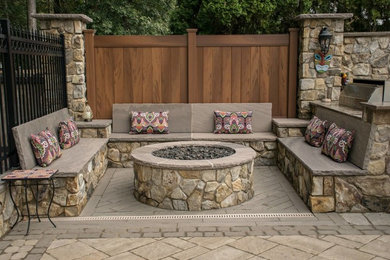 Inspiration for a large country backyard patio in New York with a fire feature, concrete pavers and no cover.