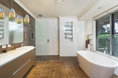 Trendy brown tile brown floor bathroom photo in Other with flat-panel cabinets, brown cabinets, white walls, a drop-in sink and white countertops