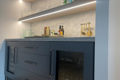 Mid-sized minimalist single-wall light wood floor and beige floor home bar photo in Los Angeles with shaker cabinets, blue cabinets, quartzite countertops, gray backsplash, stone slab backsplash and gray countertops