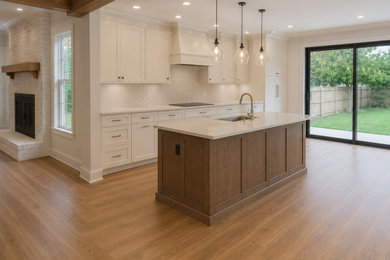 Inspiration for a huge transitional laminate floor kitchen remodel in Houston with raised-panel cabinets, white cabinets, quartzite countertops, white backsplash, porcelain backsplash, an island and white countertops