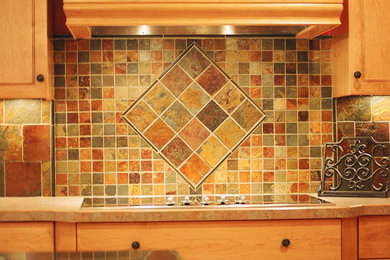 Example of a classic light wood floor kitchen design in Minneapolis with light wood cabinets, multicolored backsplash, stainless steel appliances and an island
