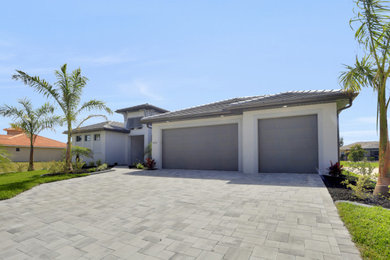 Example of a large trendy one-story house exterior design in Other with a tile roof