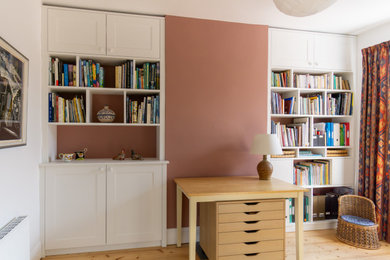 Inspiration for a medium sized classic enclosed living room with pink walls, light hardwood flooring and a chimney breast.