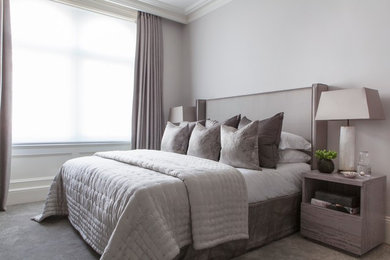 This is an example of a transitional bedroom in London with grey walls and carpet.