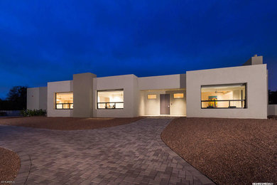 Example of a huge trendy white one-story adobe exterior home design in Phoenix