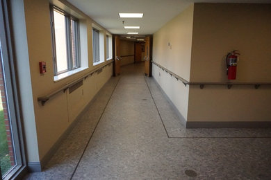 Aménagement d'un très grand couloir rétro avec un mur beige, sol en stratifié et un sol gris.