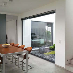 ハノーファーの中サイズのコンテンポラリースタイルのLDKの画像 (白い壁、コンクリートの床、両方向型暖炉)