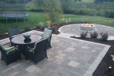 Modern backyard patio in Chicago with brick pavers and no cover.