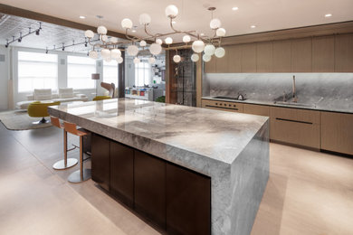Huge concrete floor and gray floor kitchen photo in New York with an undermount sink, flat-panel cabinets, medium tone wood cabinets, marble countertops, gray backsplash, marble backsplash, paneled appliances, an island and gray countertops