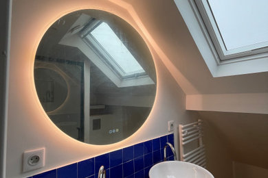 パリにあるお手頃価格のおしゃれなバスルーム (浴槽なし) (アルコーブ型シャワー、壁掛け式トイレ、青いタイル、竹フローリング、木製洗面台、開き戸のシャワー、洗面台2つ) の写真