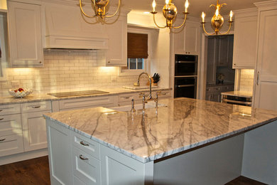 Example of a mid-sized country l-shaped dark wood floor eat-in kitchen design in Raleigh with a farmhouse sink, beaded inset cabinets, white cabinets, marble countertops, white backsplash, subway tile backsplash, white appliances and an island