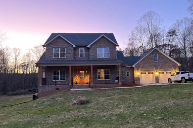 Elegant beige two-story brick house exterior photo in Charlotte with a shingle roof and a gray roof