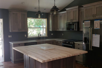 Inspiration for a large contemporary l-shaped laminate floor and multicolored floor kitchen remodel in Other with an undermount sink, shaker cabinets, light wood cabinets, quartz countertops, black appliances, an island and white countertops