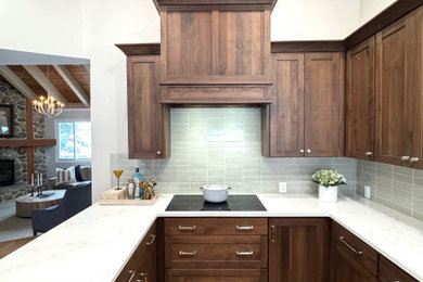 Inspiration for a mid-sized timeless l-shaped medium tone wood floor, brown floor and vaulted ceiling enclosed kitchen remodel in Other with an undermount sink, shaker cabinets, medium tone wood cabinets, quartz countertops, green backsplash, subway tile backsplash, paneled appliances and white countertops