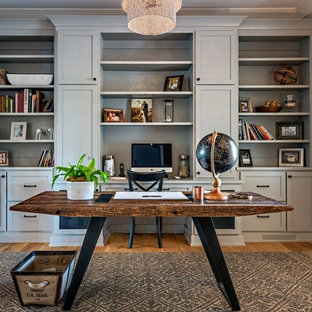 This is an example of a medium sized farmhouse study in Nashville with grey walls, medium hardwood flooring, no fireplace, a freestanding desk and brown floors.