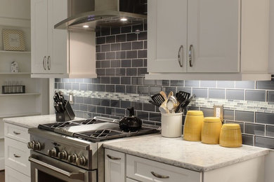 Inspiration for a mid-sized transitional dark wood floor and brown floor eat-in kitchen remodel in Other with a double-bowl sink, shaker cabinets, white cabinets, marble countertops, gray backsplash, subway tile backsplash and stainless steel appliances