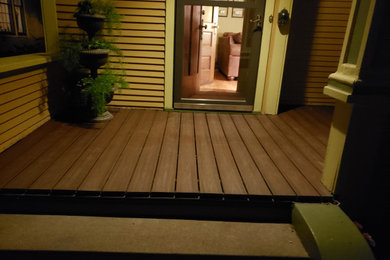 Mid-sized minimalist wood railing front porch idea in Minneapolis with a roof extension