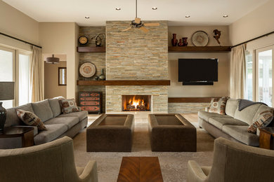 Design ideas for a large transitional open concept living room in Phoenix with beige walls, light hardwood floors, a standard fireplace, a stone fireplace surround, a wall-mounted tv and beige floor.