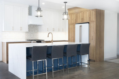 Eat-in kitchen - mid-sized l-shaped eat-in kitchen idea in Calgary with a farmhouse sink, shaker cabinets, quartz countertops, ceramic backsplash and an island