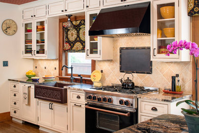 Mid-sized elegant galley medium tone wood floor enclosed kitchen photo in Omaha with a farmhouse sink, beaded inset cabinets, granite countertops, beige backsplash, stone tile backsplash, black appliances, an island and beige cabinets
