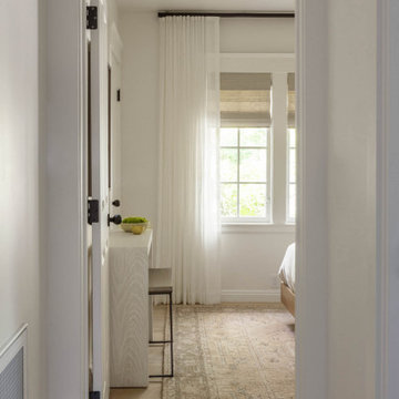Hallway Perspective into Bedroom with Layered Drapery and Neutral Rug