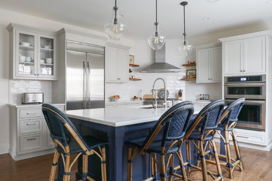 Kitchen - large transitional l-shaped medium tone wood floor and brown floor kitchen idea in New York with an undermount sink, gray cabinets, quartzite countertops, white backsplash, subway tile backsplash, stainless steel appliances, an island, white countertops and shaker cabinets