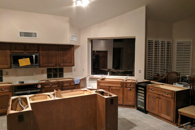 ナッシュビルにある高級な広いおしゃれなキッチン (落し込みパネル扉のキャビネット、中間色木目調キャビネット、シルバーの調理設備、三角天井) の写真