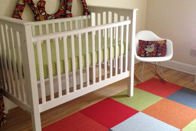 Nursery - mid-sized contemporary gender-neutral medium tone wood floor nursery idea in Cleveland with beige walls