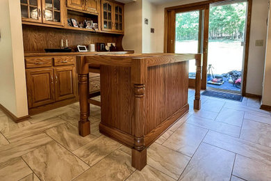 Large elegant galley eat-in kitchen photo in Cleveland with an undermount sink, beaded inset cabinets, medium tone wood cabinets, quartz countertops, beige backsplash, ceramic backsplash, an island and white countertops